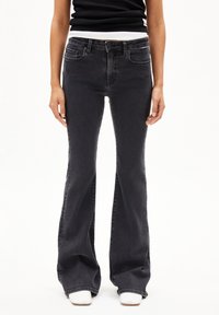 Slim-fit, zwarte flared jeans met vijf zakken, een ritsgulp en metalen hardware details. Zachte denimtextuur met een lichte vervaging.