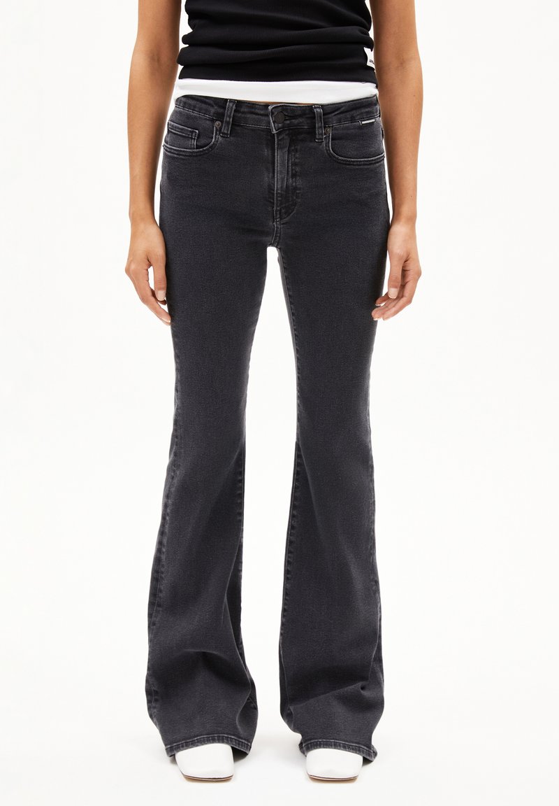 Slim-fit, zwarte flared jeans met vijf zakken, een ritsgulp en metalen hardware details. Zachte denimtextuur met een lichte vervaging.