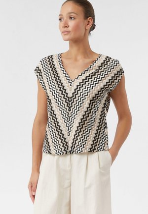 Kurzes Oberteil mit V-Ausschnitt und einem Zickzackmuster in Beige, Schwarz und Weiß. Hergestellt aus leichtem Stoff mit entspannter Passform.