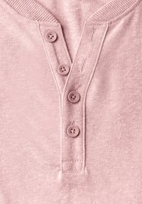 Světle růžové triko henley z texturovaného materiálu, se třemi knoflíky na légě a žebrovaným límcem a manžetami.