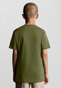 Olivengrøn bomulds T-shirt med korte ærmer, rund hals og afslappet pasform. Glat tekstur med et enkelt design. Vist fra ryggen.