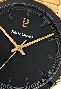 Esfera de reloj negra con acentos dorados, que presenta un logotipo dorado de "P" y manecillas, un bisel negro texturizado, marcadores de horas minimalistas y un diseño elegante.