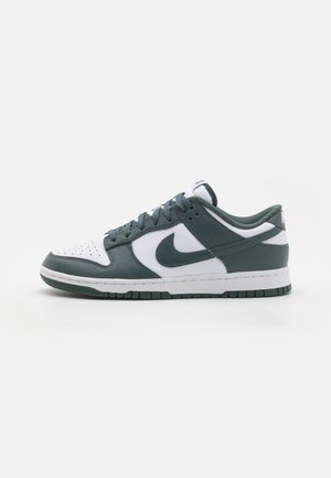 Nike Dunk Low sneaker featuring a white leather toe cap, green leather sides, and a white midsole. Textured accents and flat laces included.