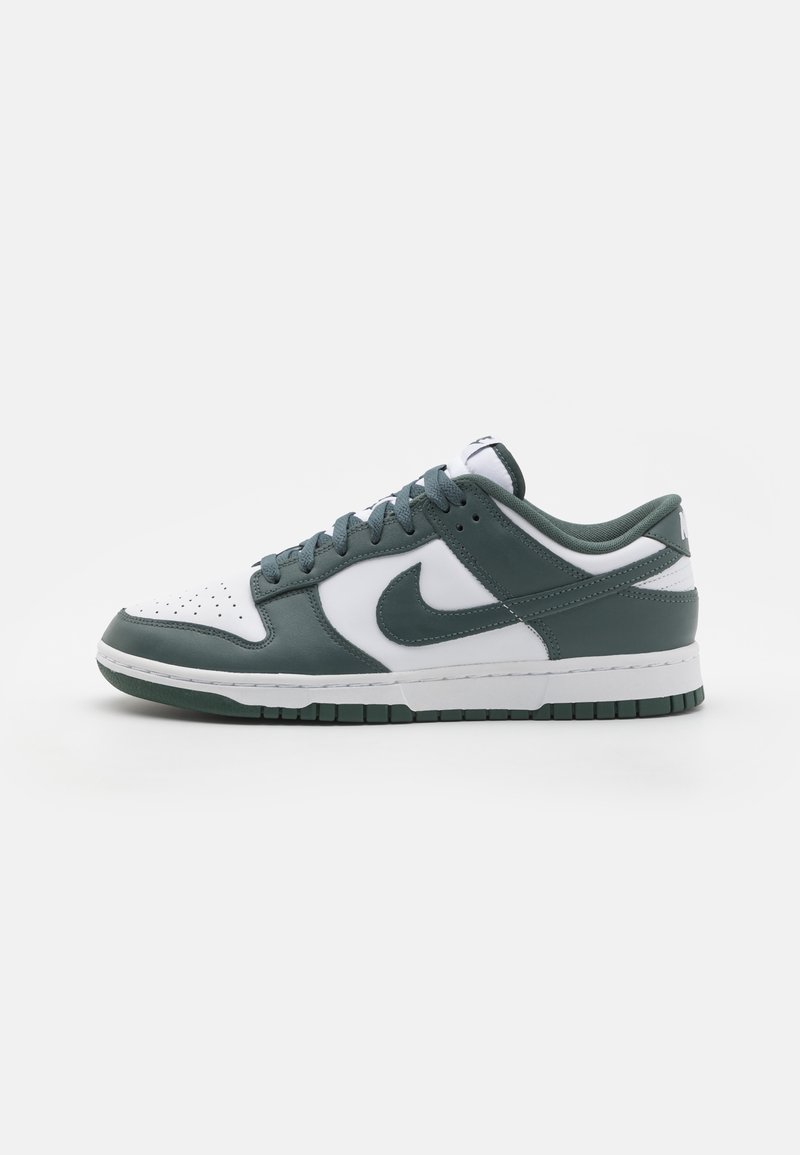 Nike Dunk Low sneaker featuring a white leather toe cap, green leather sides, and a white midsole. Textured accents and flat laces included.