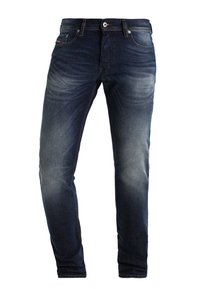 Mörkblå denimjeans med slim fit, lätt blekning på benen, synlig sömnad, fem fickor och gylf med knappar.