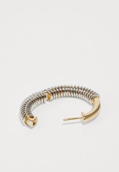 Cercei din metal în formă de cerc, cu un design spiralat din argint și un accent de aur, având închidere cu pin drept. Textură netedă cu culori contrastante.
