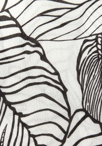 Tessuto bianco e nero con audaci motivi astratti a forma di foglia. La texture appare morbida con una trama simile al lino. Dettagli intricati nel design.