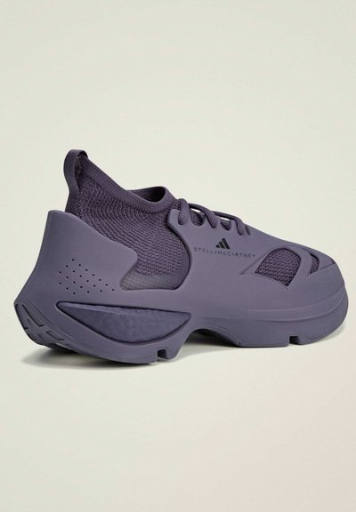 Purple athletic shoes with a sleek design feature a textured fabric upper, rubber sole, and cut-out accents for ventilation.