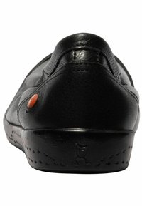 Zapato negro de cuero sin cordones con punta redonda, textura suave, pequeño acento naranja y detalle de suela perforada.