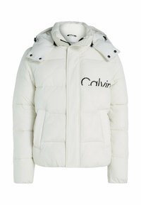 Veste matelassée blanche avec fermeture éclair, capuche et texture matelassée. Comprend des poches latérales et le logo « Calvin » en noir sur le devant.