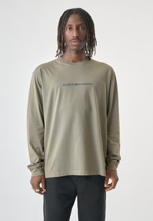 Olive green long-sleeve t-shirt made of soft fabric, featuring a small blue graphic text across the chest. Classic crew neck design.