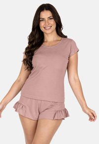 Conjunto de pijama rosa claro que incluye una camiseta de manga corta y pantalones cortos con volantes. Fabricado con un tejido suave, de textura lisa y ajuste cómodo.