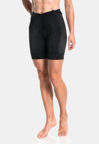 Pantalones cortos de ciclismo negros con un ajuste ajustado, con un inserto acolchado, paneles de malla texturizada en los lados y una banda elástica ancha en la cintura.