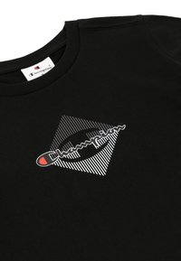 Czarny bawełniany sweter z okrągłym dekoltem, z białym i czerwonym logo Champion wzdłuż paskowanego wzoru w romb na przodzie oraz miękką fakturą.