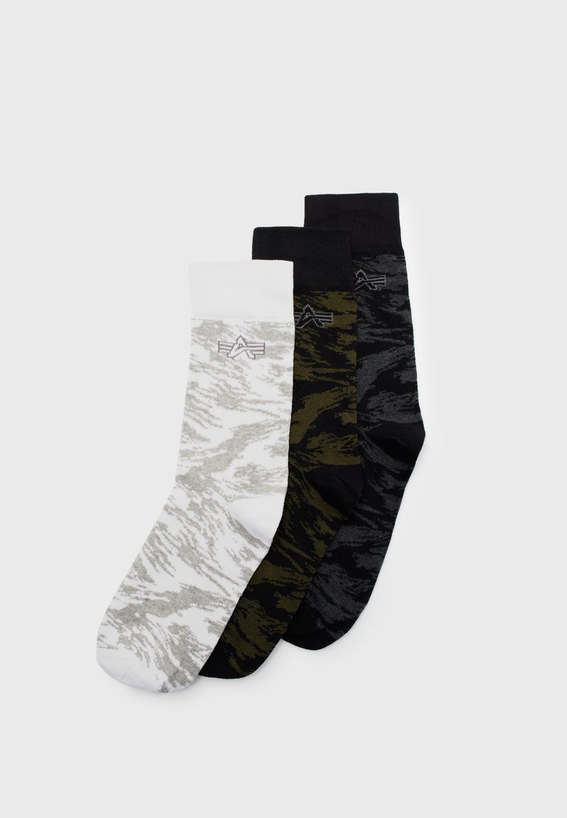 Tre par strumpor: vita med grått mönster, olivgröna och svarta, var och en med en subtil design och ribbade muddar.