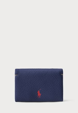 Navy lærwallet med teksturert overflate, gull detaljer og en rød polo spillerlogo på forsiden. Rektangulær form.