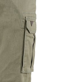 Khaki cargo kalhoty se boční kapsou s dekorativním trojúhelníkovým akcentem, vyrobené z odolné bavlněné tkaniny s hladkou strukturou.