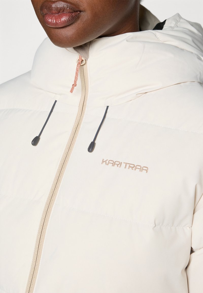 Kremowa kurtka puchowa z kapturem, z zamkiem błyskawicznym z przodu, regulowanymi trokami i haftowanym logo w różowym złocie.