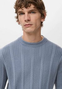 Jasnoniebieski sweter dziany z pionowym prążkowaniem i wzorami warkoczy, okrągłym dekoltem i miękką fakturą.