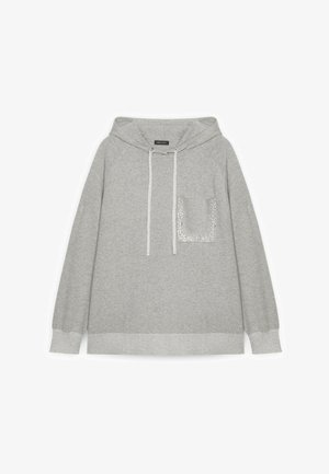 Sweat à capuche gris clair avec une poche frontale ornée de petites décorations florales blanches et des cordons de serrage.