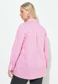 Roze en witte gestreepte blouse met lange mouwen, knoopmanchetten, een achterkant met yoke en een gebogen zoom. Gladde stof met een strakke afwerking.