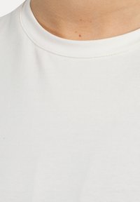 Hvid bomulds t-shirt med en klassisk round neck, glat tekstur og subtil syning detalje ved halsudskæringen.