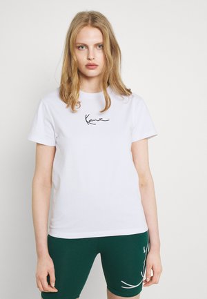 Hvit bomulls T-skjorte med korte ermer og rund hals, med en svart grafisk logo brodert på brystet.