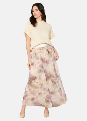 Un pull en tricot léger associé à une longue jupe maxi fluide à fleurs pastel, dotée d'un design superposé et d'une taille élastique.