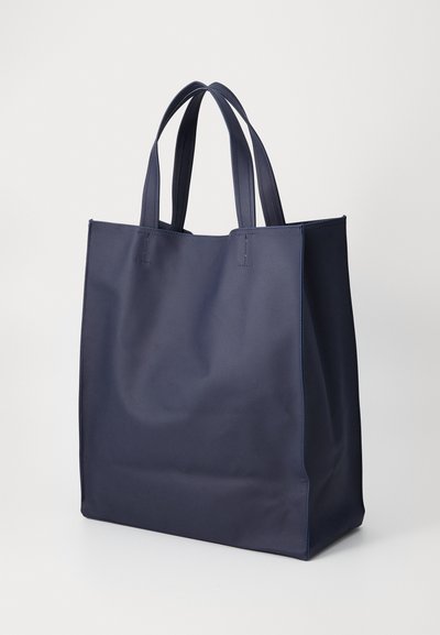 Marineblå toteveske laget av glatt stoff, med doble håndtak og et enkelt, uten dekorasjoner design. Ingen synlig maskinvare eller mønstre.