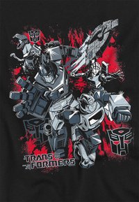 Schwarzes T-Shirt mit einem Grafik von mehreren robotischen Charakteren in Grau und Rot, mit dem deutlich sichtbaren "Transformers"-Logo.