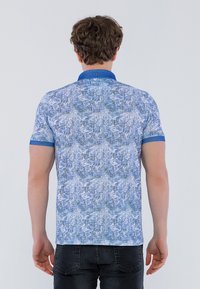 Kortærmet polo-shirt, blå med et tekstureret mønster, der har en ensfarvet blå krave og ærmekanter, lavet af letvægtsstof.