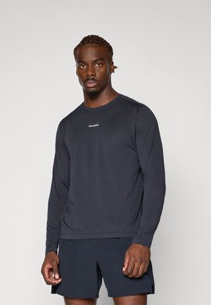 Mørk langærmet atletisk skjorte lavet af letvægtsstof, med rund halsudskæring og logoet "SALOMON" i hvidt på brystet.