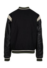 Sort bomberjakke med en uldkrop og lædersleeves. Ribbet krave og manchetter i grøn og hvid. Bagview viser ensfarvet og tekstur.