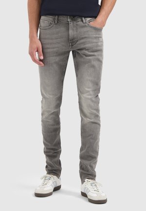 Slim-fit grijze denim jeans met een vervaagde wassing, vijf-pocket ontwerp en subtiele stikdetails. Gepaard met witte sneakers.