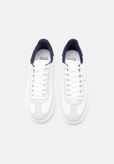 Ζευγάρι λευκά δερμάτινα αθλητικά παπούτσια με εσωτερική επένδυση σε ναυτικό μπλε, λευκά κορδόνια και διακοσμητικό σουέτ, σε άνωθεν θέα σε λευκό φόντο.