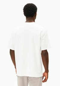 Witte katoenen T-shirt met een ontspannen pasvorm, korte mouwen en een ronde hals. Gladde textuur, zonder zichtbare patronen of afbeeldingen.