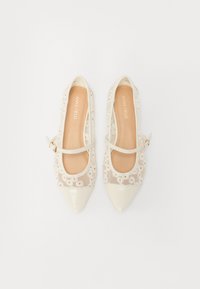 Ballerines à bout pointu avec une finition en vernis crème et une tige en maille florale transparente. Équipées d'une sangle Mary Jane avec une boucle dorée. Semelle plate.