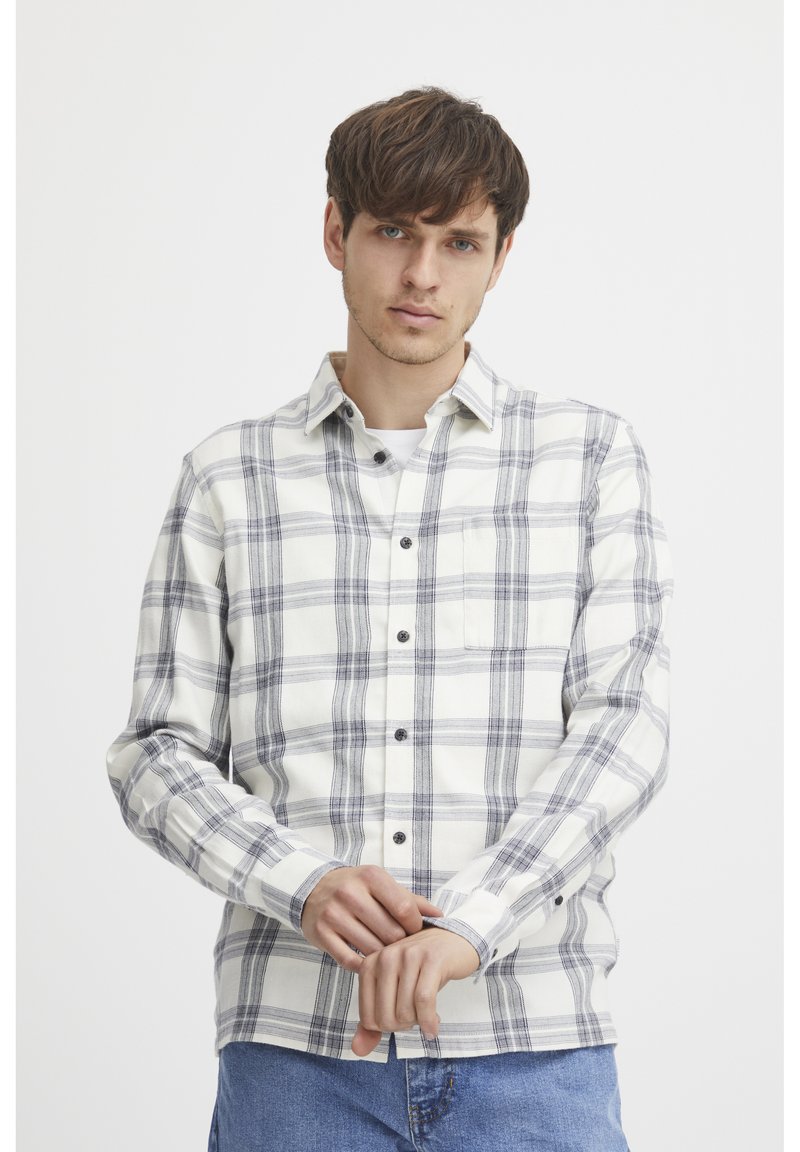 Long-sleeve plaid shirt in white and navy with button-up closure, chest pocket, and a relaxed fit. Cotton blend fabric with a soft texture.