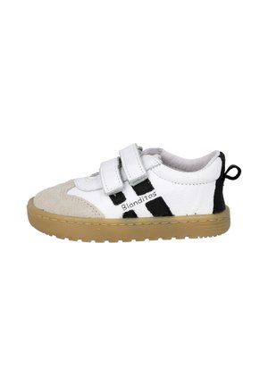 Zapatilla blanca de cuero con puntera de ante, detalles en negro y dos correas de Velcro. Suela de goma texturizada con una pestaña en la parte trasera.