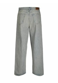 Jean en denim bleu clair à jambe large avec taille haute, comportant deux poches arrière et une étiquette en cuir sur la ceinture. Tissu doux et texturé.