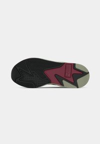 Sneaker outsole featuring a black rubber design with textured grip, maroon accents, and a gray patterned section. Branding visible on midsole.