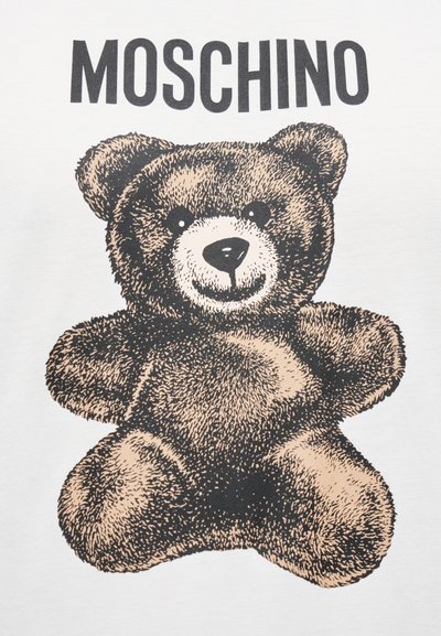 Λευκό μπλουζάκι με μεγάλο γραφικό τύπωμα αρκούδου σε καφέ αποχρώσεις με μαύρα περιγράμματα και το κείμενο "MOSCHINO" από πάνω.