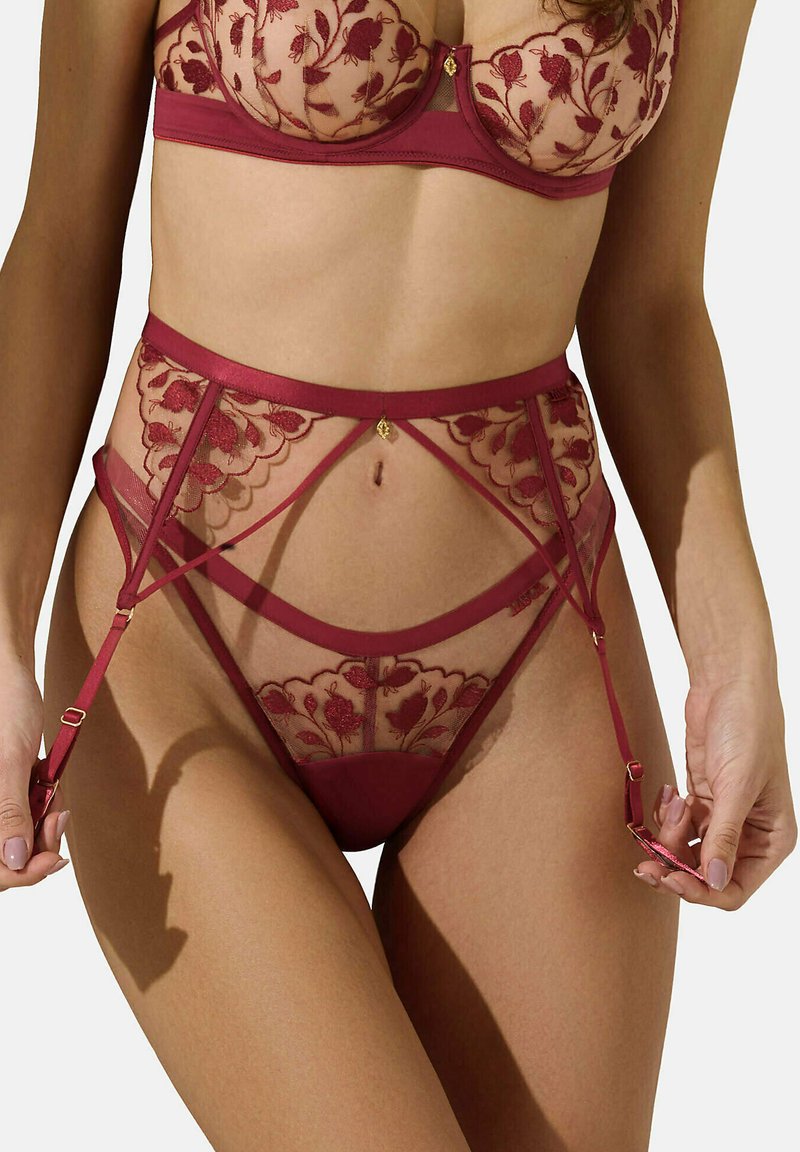 Ensemble de lingerie en dentelle bordeaux avec broderies florales, panneaux transparents, design taille haute et bretelles réglables avec accents dorés.