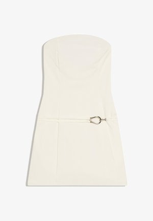 Rochie mini albă fără bretele, cu siluetă mulată și o curea subțire prevăzută cu o cataramă argintie în formă de picătură la nivelul taliei.