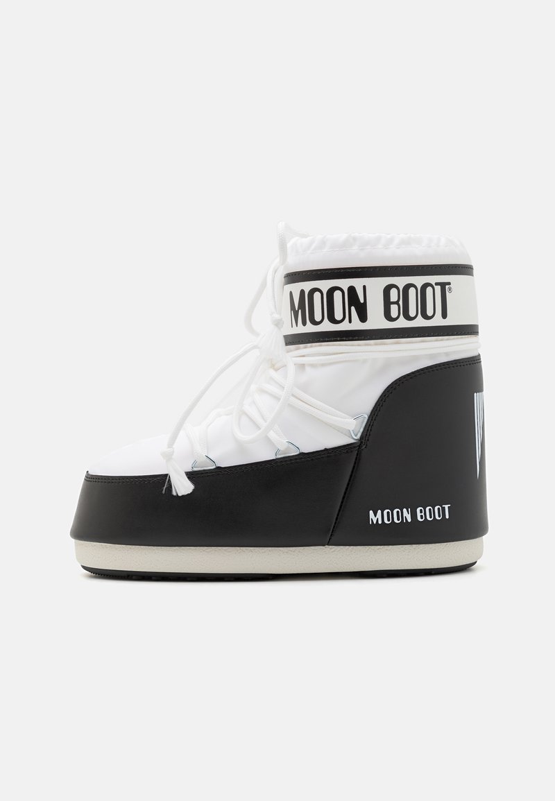 Witte en zwarte sneeuwschoen met een ronde neus, vetersluiting aan de voorkant, gevoerde enkel en "MOON BOOT" branding op de bovenrand en zijkant.