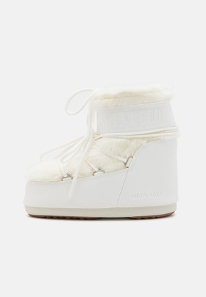 Witte Moon Boot, met een pluche leren bovenkant, dikke zool en verstelbare veters. Glad materiaal met reliëfmerken op de band en hiel.