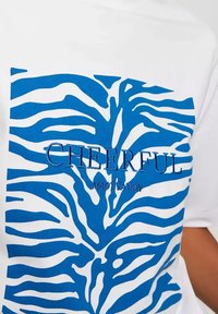 Biała koszulka z niebieskim wzorem w paski zebry, z wyszywanym na środku słowami "CHEERFUL" i "MAOTVATION" w kolorze niebieskim.