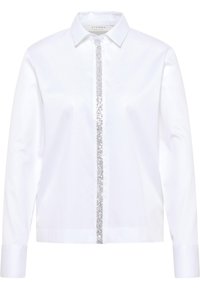 Hvid skjorte med knapper, der har en glitrende sølvpalietstribe ned langs midten, lange ærmer og en klassisk krave. Glat stofstruktur.