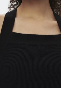 Zwarte geribbelde tanktop met een vierkante halslijn en brede schouderbanden, gemaakt van een gestructureerde breisel.