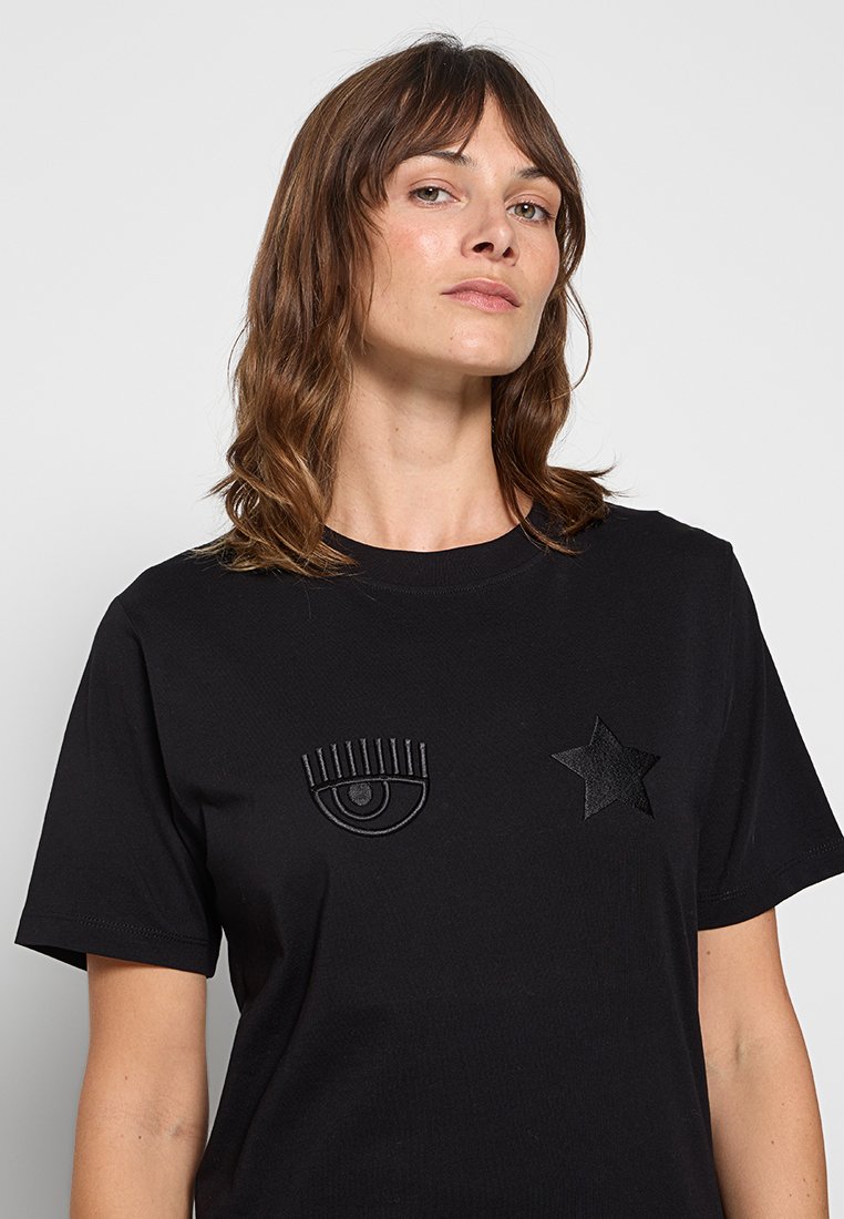 Czarny bawełniany t-shirt z teksturowanym czarnym haftem oka i gwiazdy z przodu. Okrągły dekolt i krótkie rękawy.